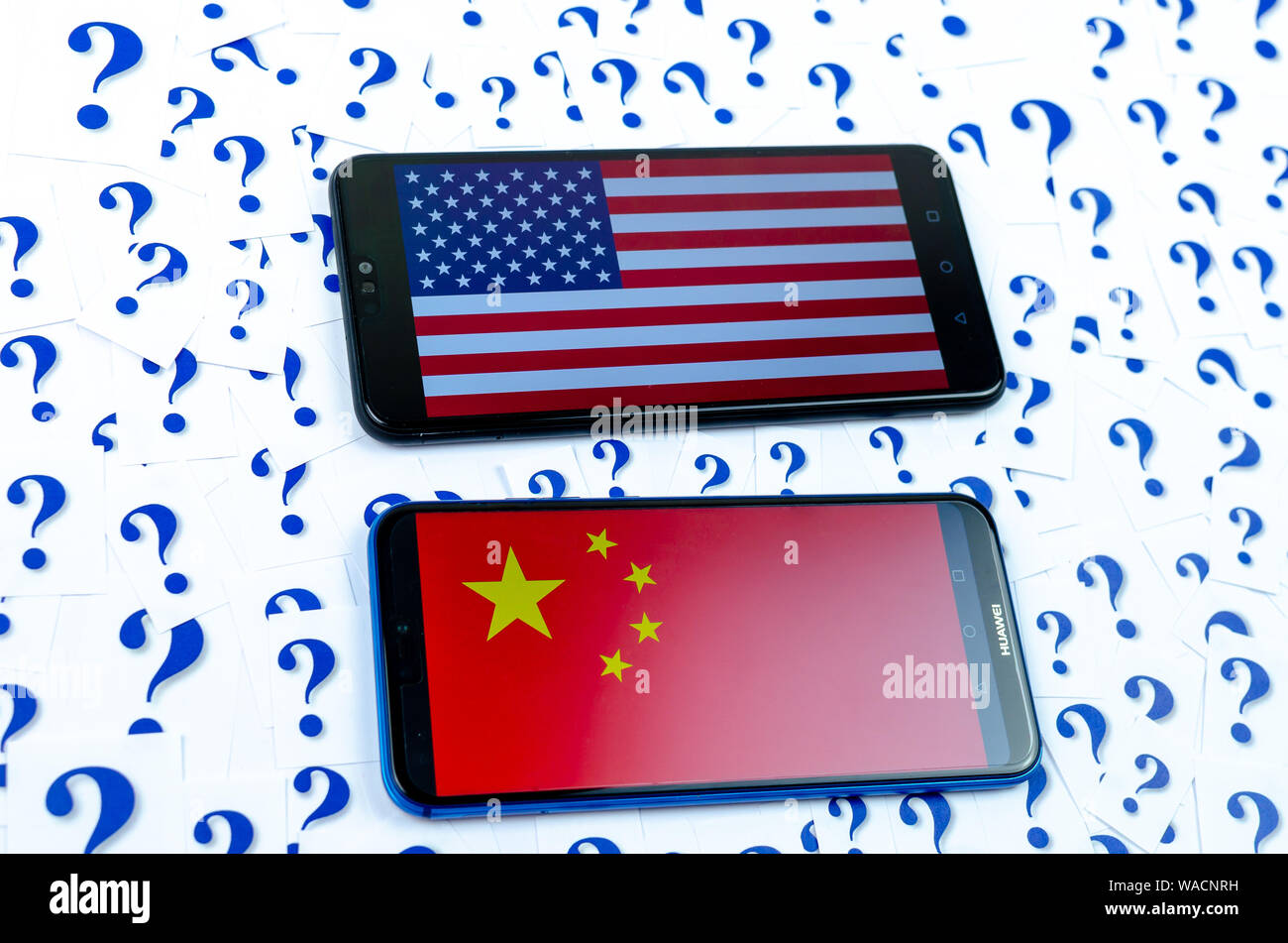 Flagge von Amerika und China auf der Huawei smartphones und eine Menge Fragezeichen um. Die konzeptuellen Foto über Zukunft der uns China Beziehung Stockfoto