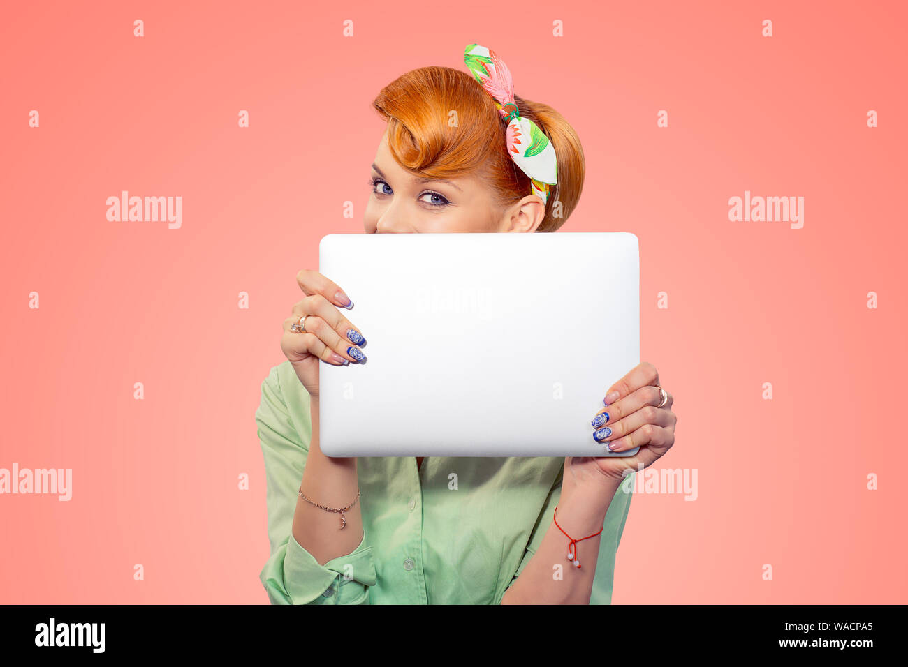 Student versteckt sich hinter Laptop. Closeup Portrait headshot Schöne nette junge geschäftsfrau Pinup girl Holding Übersicht Computer auf Pfirsich isolierte Rosa Stockfoto