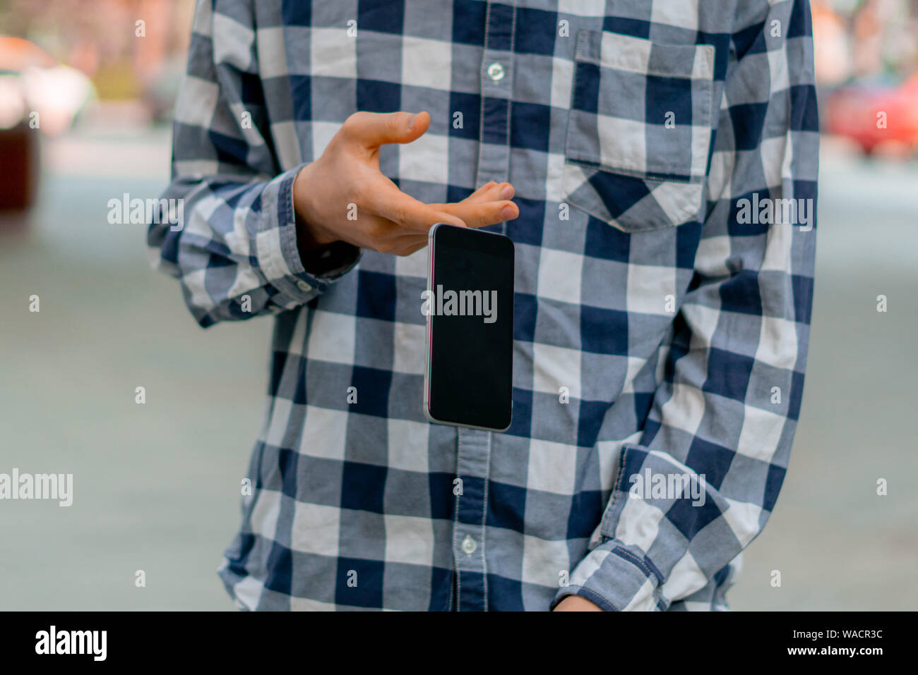 Person, die ein Smartphone auf der Straße, ein Telefon zu fallen und Sie fliegen durch einen Unfall Stockfoto