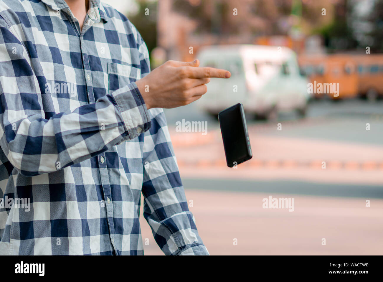 Person, die ein Smartphone auf der Straße, ein Telefon zu fallen und Sie fliegen durch einen Unfall Stockfoto
