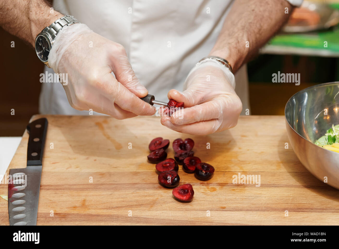 Koch ist entfernen Steine von Cherry in der professionellen Küche Stockfoto
