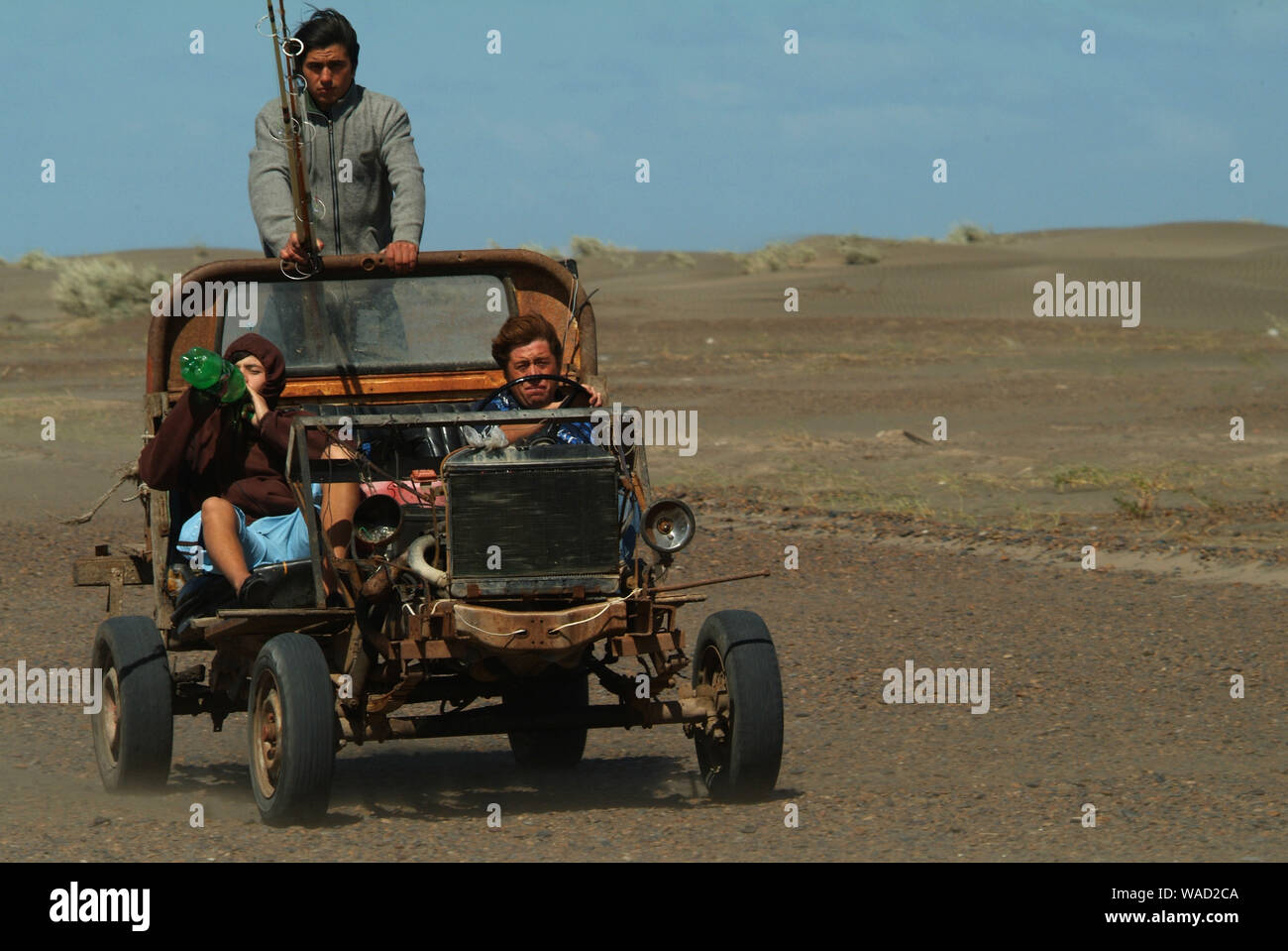 Zwei Fischer, ein Stand Up und das andere Sitzmöbel, und trinken, und eine Frau, die ein Buggy, lokale Auto , Fahren offroad in Sand und Wüste Stockfoto