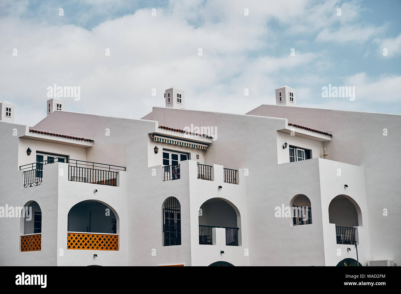Modernes Gebäude mit weißen Wänden und großen Balkonen gegen bewölkter Himmel entfernt auf der Straße auf Teneriffa Stockfoto