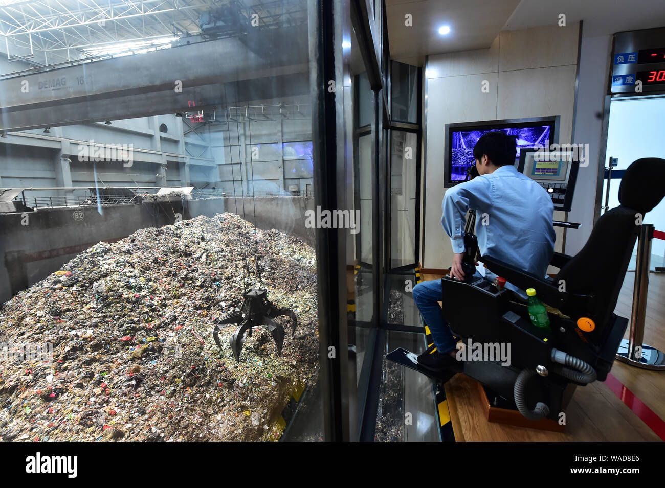 Chinesische Mitarbeiter überwachen die Müllverbrennung Strom auf der soliden Müllverbrennungsanlage von China Everbright International Lim zu generieren Stockfoto