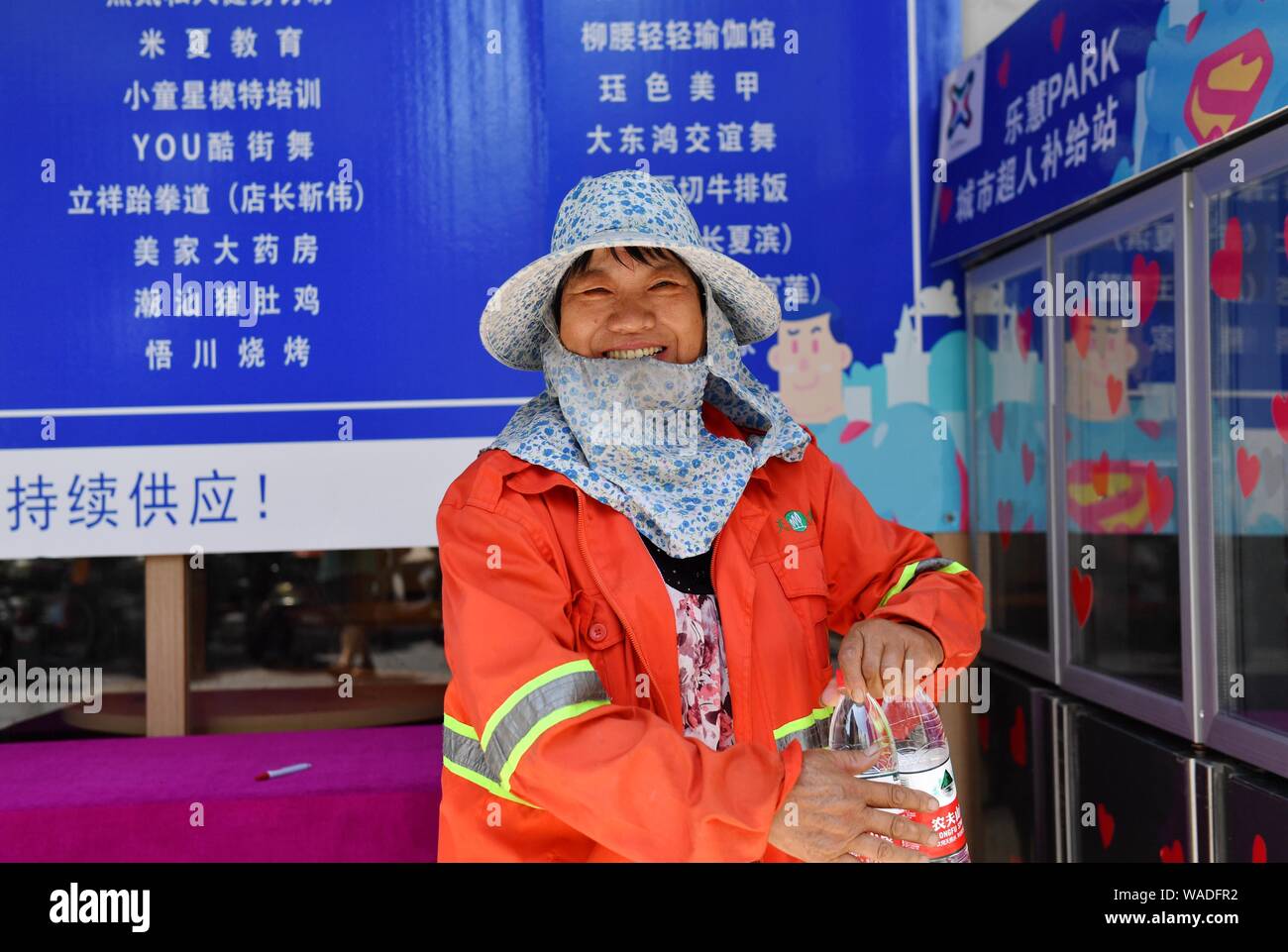 Eine Abwasserentsorgung Arbeiter nehmen Flaschen Wasser aus der Gemeinschaft Kühlschrank bei Straße in Hangzhou Yuhang Bezirk, Stadt, East China ¯ s Zhejiang Provinz, 25. Stockfoto