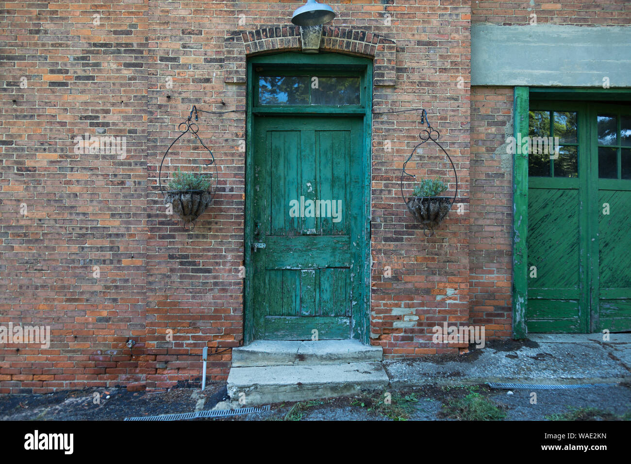 Eine grüne Tür dient als Eingang zu einem alten Backsteingebäude an Frau Lager Park in Hillsdale, Michigan, USA. Stockfoto