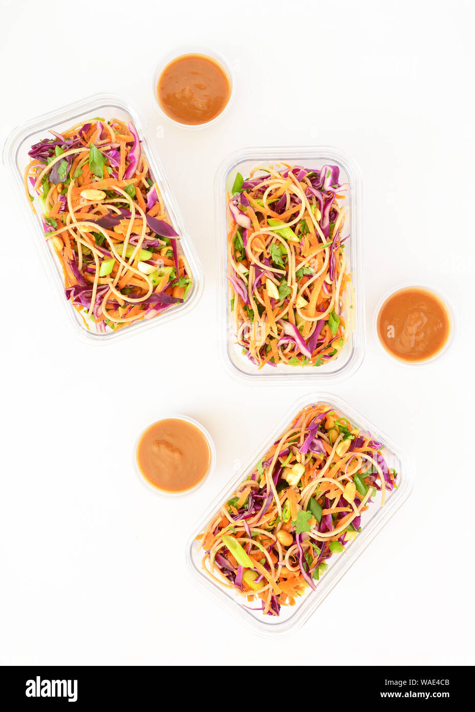Frische hausgemachte Thailändischer Nudelsalat mit Erdnuss-sauce in Essen prep Container für das Mittagessen. Auf weißem Hintergrund in Flach Komposition. Stockfoto