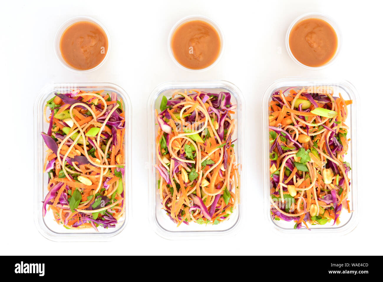 Frische hausgemachte Thailändischer Nudelsalat mit Erdnuss-sauce in Essen prep Container für das Mittagessen. Auf weißem Hintergrund in Flach Komposition. Stockfoto