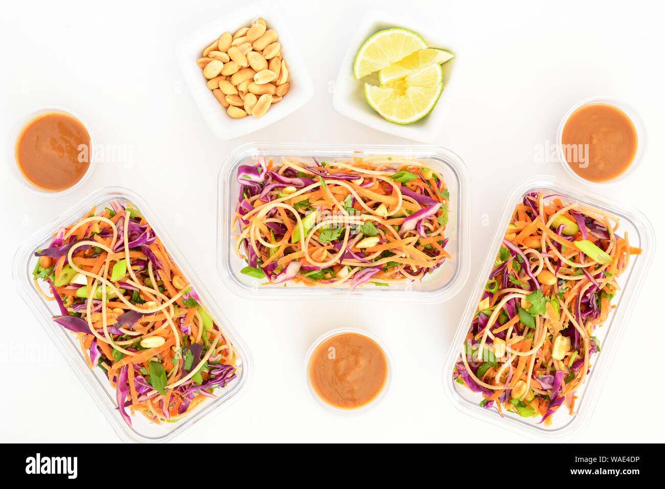 Frische hausgemachte Thailändischer Nudelsalat mit Erdnuss-sauce in Essen prep Container für das Mittagessen. Auf weißem Hintergrund in Flach Komposition. Stockfoto