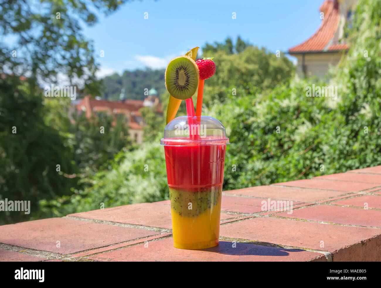 Sommer frisches Obst Aromatisierte infundiert Wasser Mischung aus Kiwi, Mango und Erdbeere im Kunststoff Glas zum Mitnehmen bereit. Stockfoto