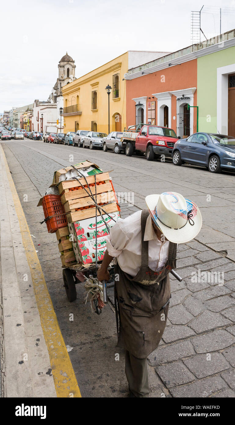 Mexikanische mann Arbeiter Ziehen schwerer Last wagen voll von Produkten auf den Markt, Oaxaca City, Oaxaca, Mexiko landwirtschaftliche Arbeitnehmer Stockfoto