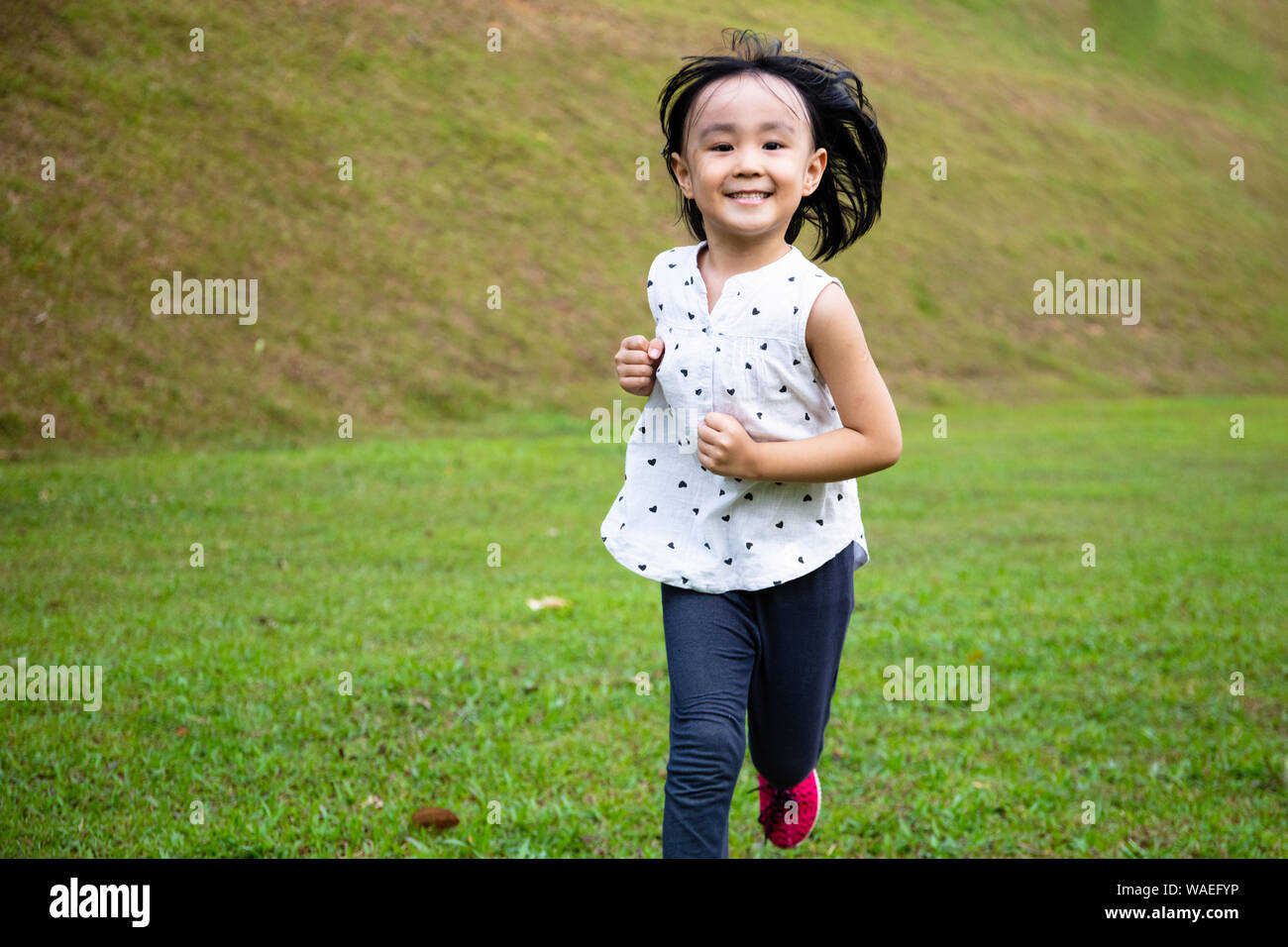 Asiatische kleinen chinesischen Mädchen glücklich läuft im Park Stockfoto