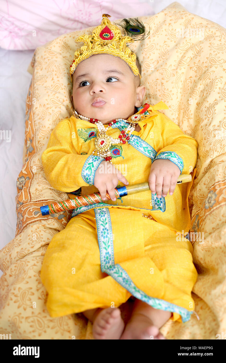 Bild von Indischen Kind tragen Lord Krishna Kostüm und feiern Janmashtami Festival. Isoliert weißer Hintergrund. Stockfoto