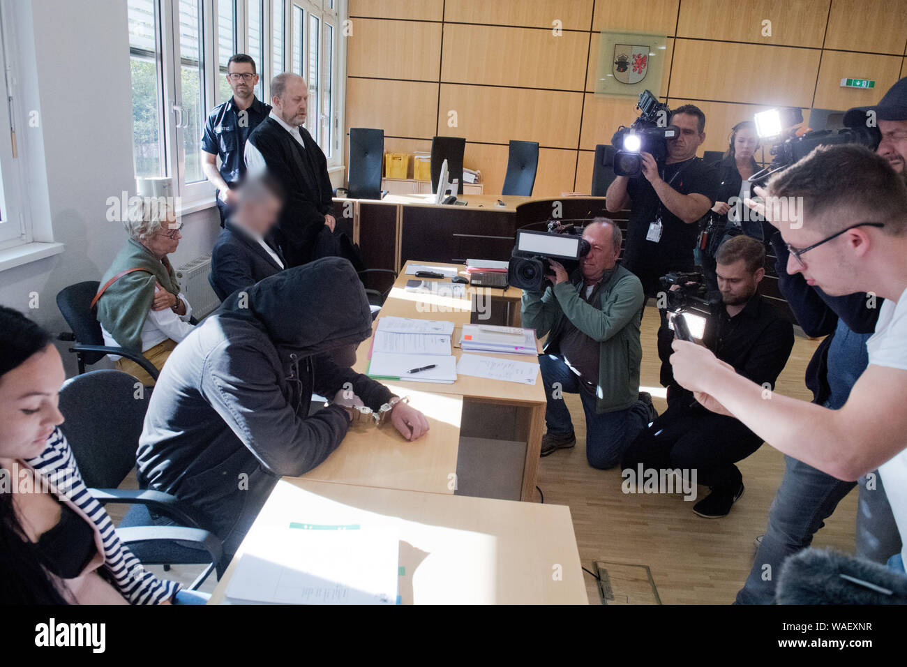 Stralsund, Deutschland. 20 Aug, 2019. Der 19-jährige Beklagte (2. von links) verbirgt sein Gesicht in den Gerichtssaal des Landgerichts. Für die Ermordung der 18-jährigen Maria aus Zinnowitz auf Usedom, die 19-Jährige und eine 21-Jährige (4. von links) beim Gerichtshof haben am gleichen Tag zu beantworten. Die Staatsanwaltschaft wirft ihnen der Schleichend tötet schwangere Maria Mitte März 2019 von Mord. Quelle: Stefan Sauer/dpa-Zentralbild/dpa - ACHTUNG: Person(en) pixelated sind aus rechtlichen Gründen/dpa/Alamy leben Nachrichten Stockfoto