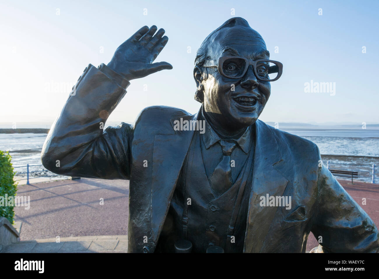 Nahaufnahme einer Statue des englischen Schauspieler Eric Morecambe in einem charakteristischen auf Marine Road Central, Morecambe Bay, Lancs, Großbritannien dar Stockfoto