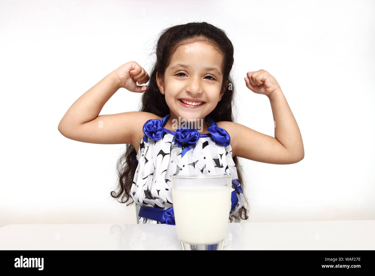 Mädchen mit Milchglas und zeigt ihre biegen Muskeln Stockfoto