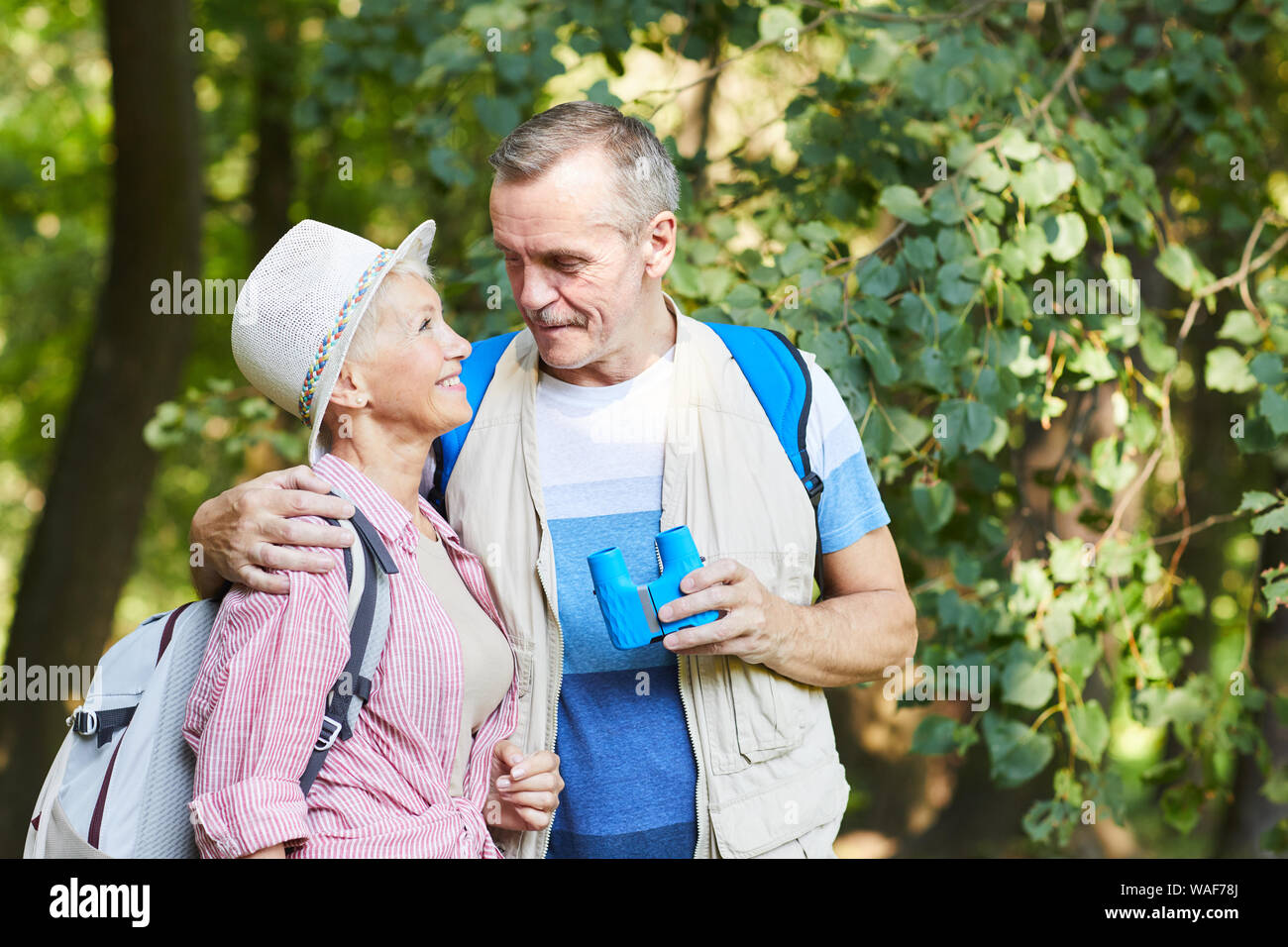 Gerne älteres Paar Touristen umarmen und an jedem anderen suchen während ihrer Reise in den Wald im Sommer Tag Stockfoto