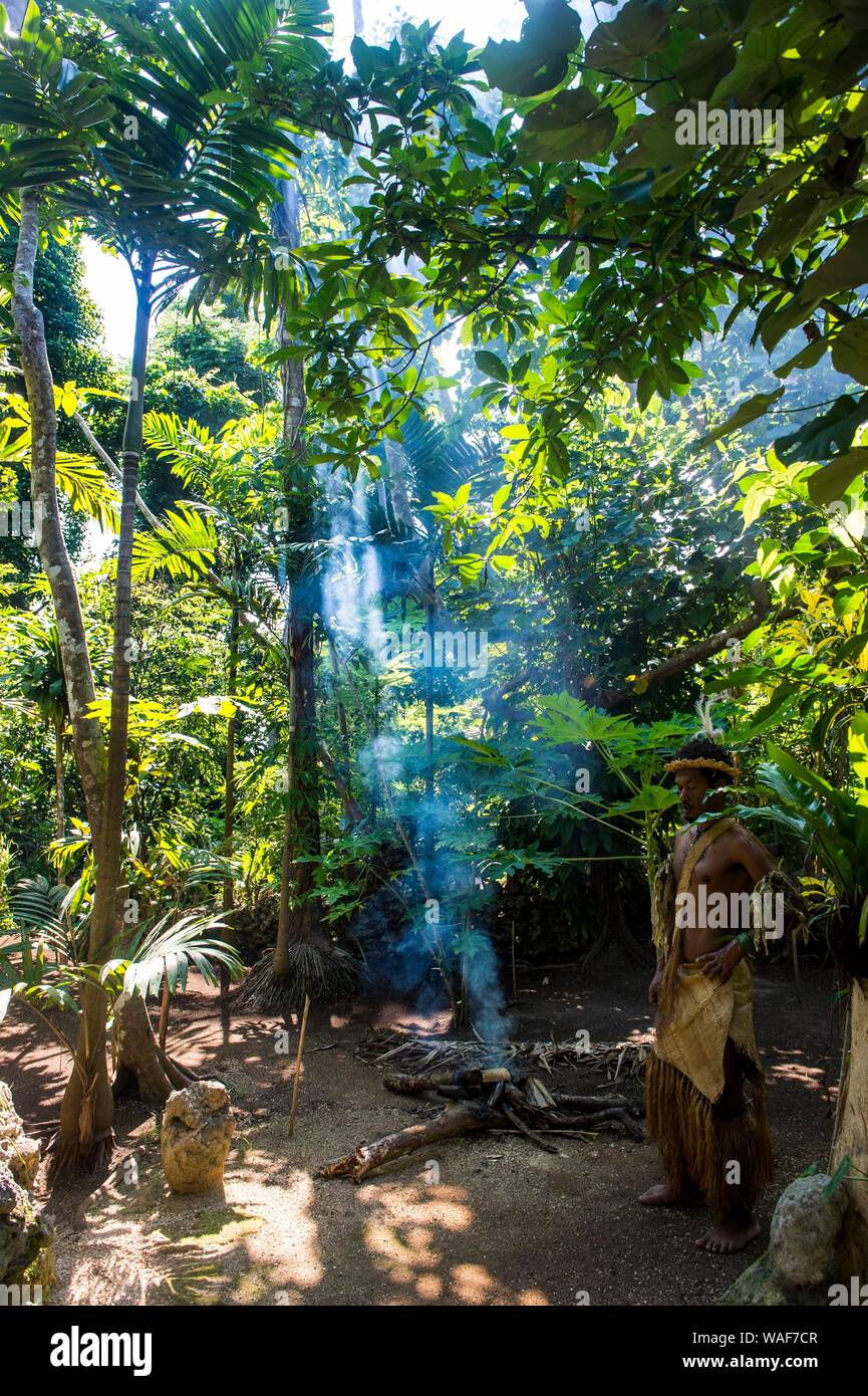 Traditionelle gekleideter Mann im Dschungel in der Nähe von Feuer, Ekasup Cultural Village, Efate, Vanuatu Stockfoto