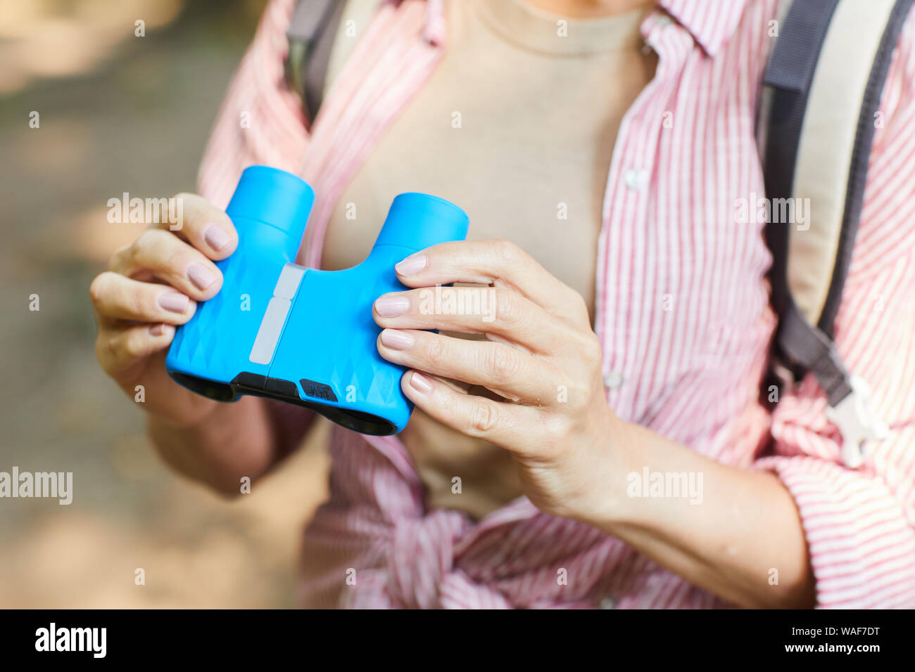 Nahaufnahme der reife Frau mit Fernglas in der Hand beim Stehen im Freien während Ihrer Reise Stockfoto