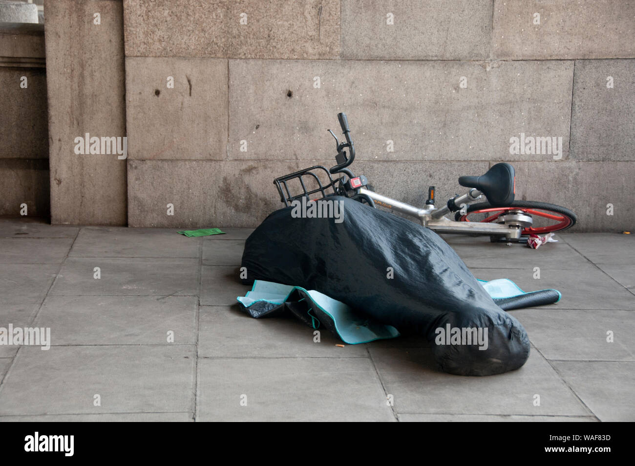 London. Themse Böschung. Obdachlose Person schlafen Neben einem Fahrrad.. Stockfoto