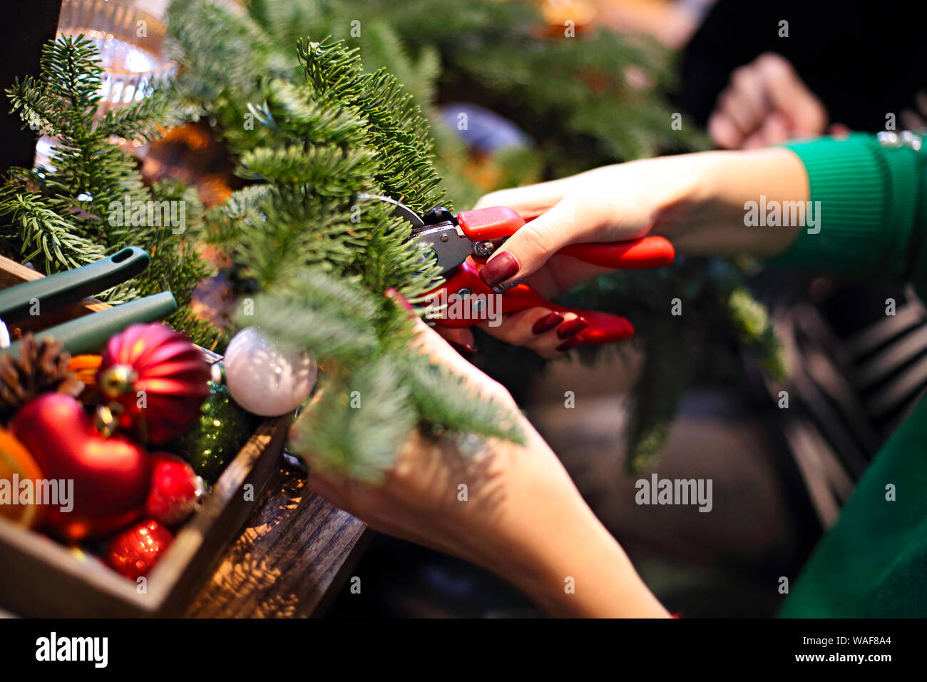 7/8-Ansicht der Familie zu Weihnachten Kranz aus Tannenzweigen, Weihnachten Kugeln und der tannenzapfen auf dem hölzernen Tisch Stockfoto