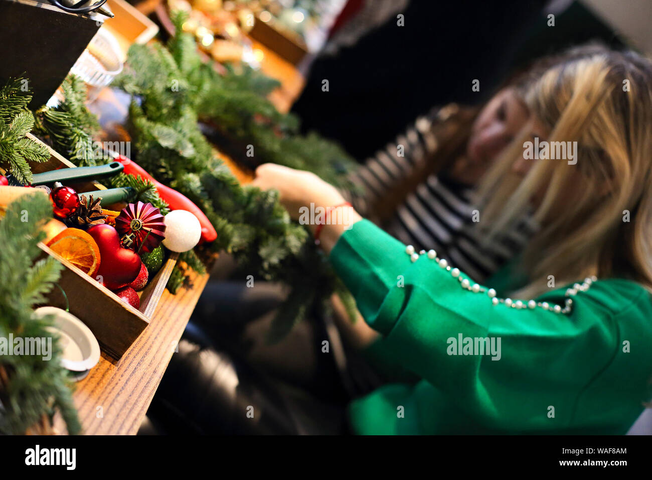 7/8-Ansicht der Familie zu Weihnachten Kranz aus Tannenzweigen, Weihnachten Kugeln und der tannenzapfen auf dem hölzernen Tisch Stockfoto