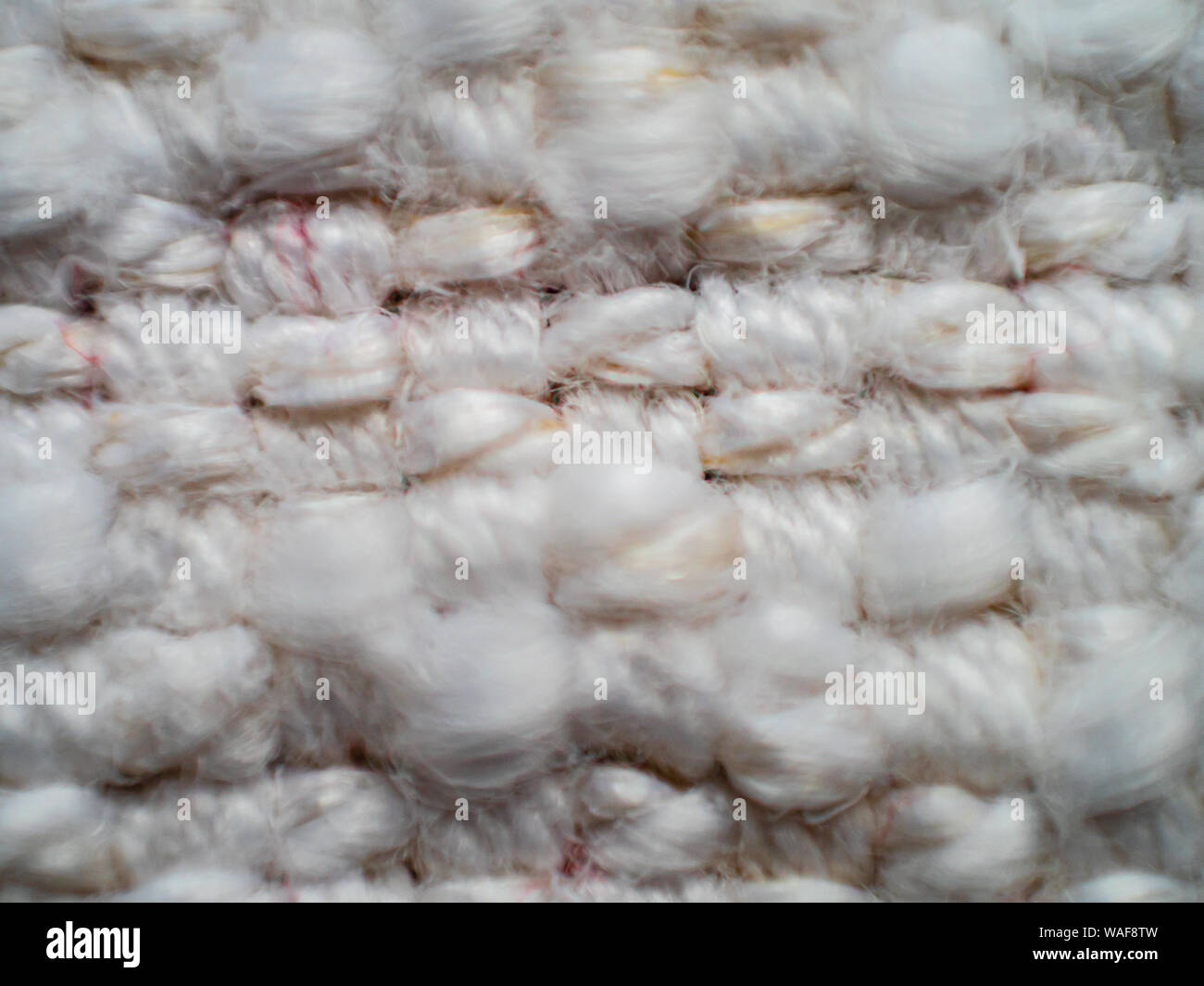 Raues strukturiertes Detail aus festem, gewebtem Teppich in Naturweiß Stockfoto