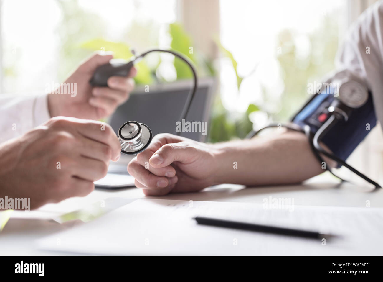 Arzt den Blutdruck eines Patienten überprüfen Stockfoto