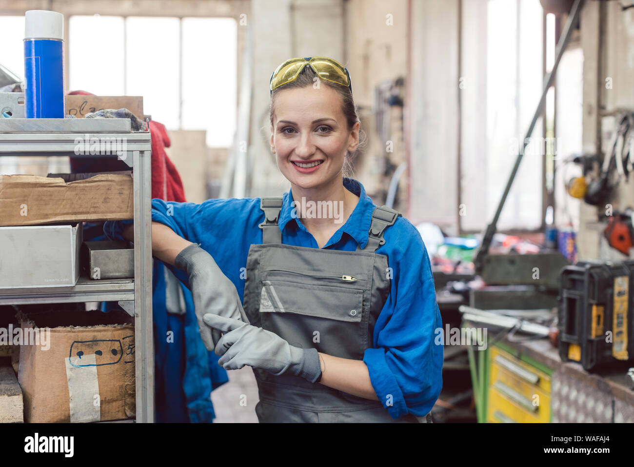 Frau Arbeiter in der Metallwerkstatt in die Kamera schaut Stockfoto
