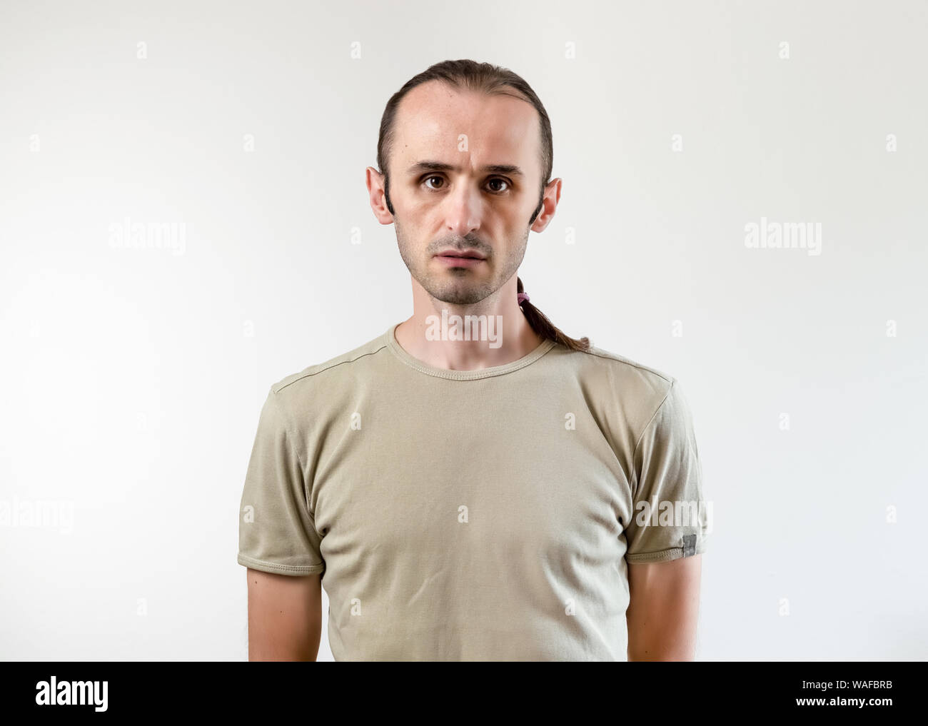 Porträt einer stattlichen brunet Mann mit stoppelbart stehen auf weißen Hintergrund. Stockfoto