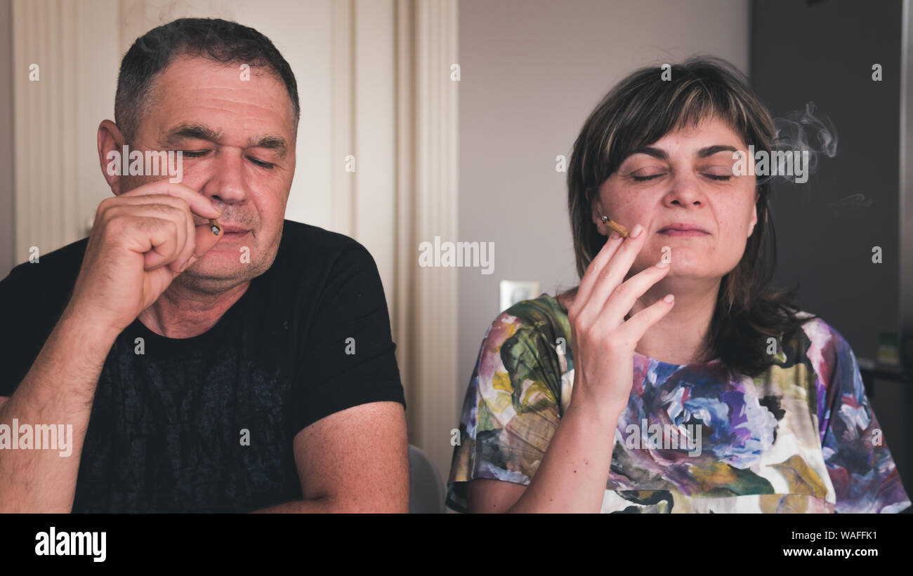 Die Paare von erwachsenen Personen rauchen Marihuana. Hanf rauchen in geschlossenen Räumen. Cannabis ist ein Konzept der Kräutermedizin Stockfoto