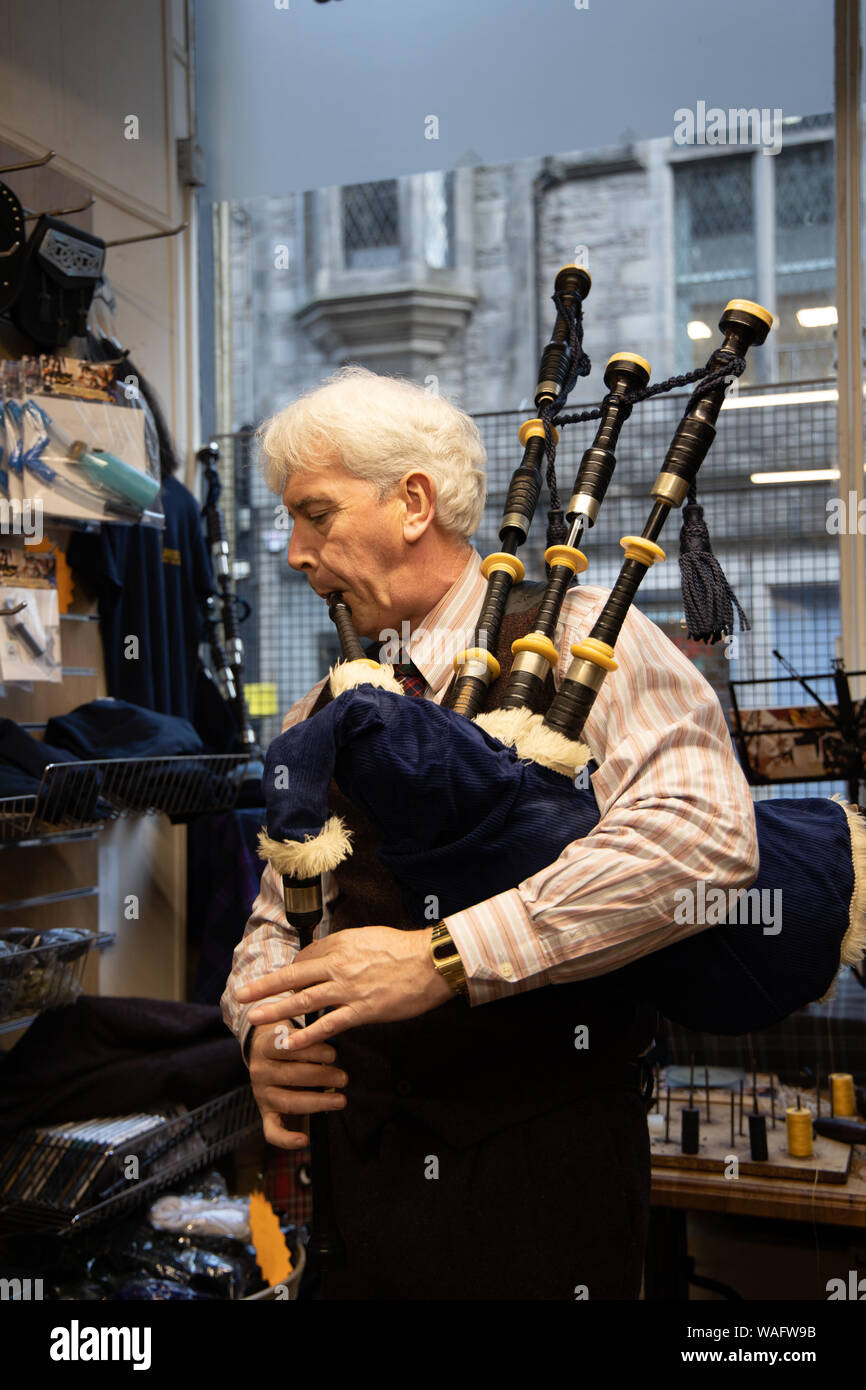 Spontanes Spielen seiner Dudelsack Edinburgh piper Alastair Wilkinson in alten Kilberry Dudelsack shop in St Mary's Street, Edinburgh, Schottland Großbritannien Stockfoto