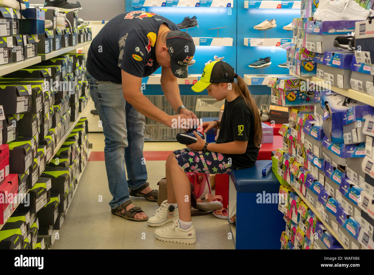Russland, Kazan - 10. August 2019: Vater und Tochter wählen Sie Sportschuhe im Store. Vorbereitung für die Schule. Zurück zu Schule. Stockfoto
