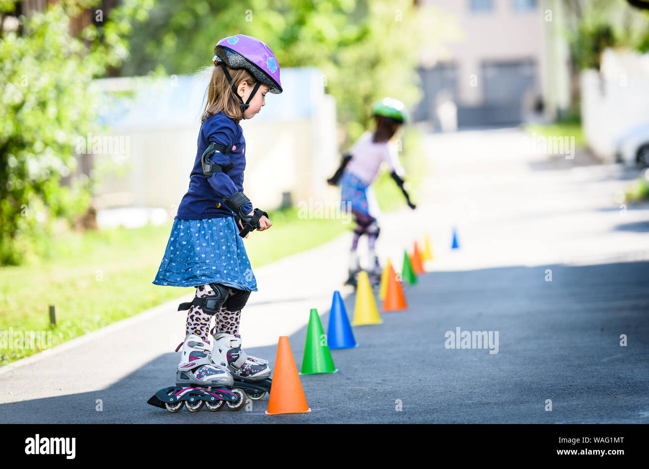 Kinder lernen, Rollschuh auf der Straße mit Zapfen. Zwillinge sind sichere  Inline Skates unterwegs eine Einfahrt nach Hause tragen schützende Gea üben  Stockfotografie - Alamy