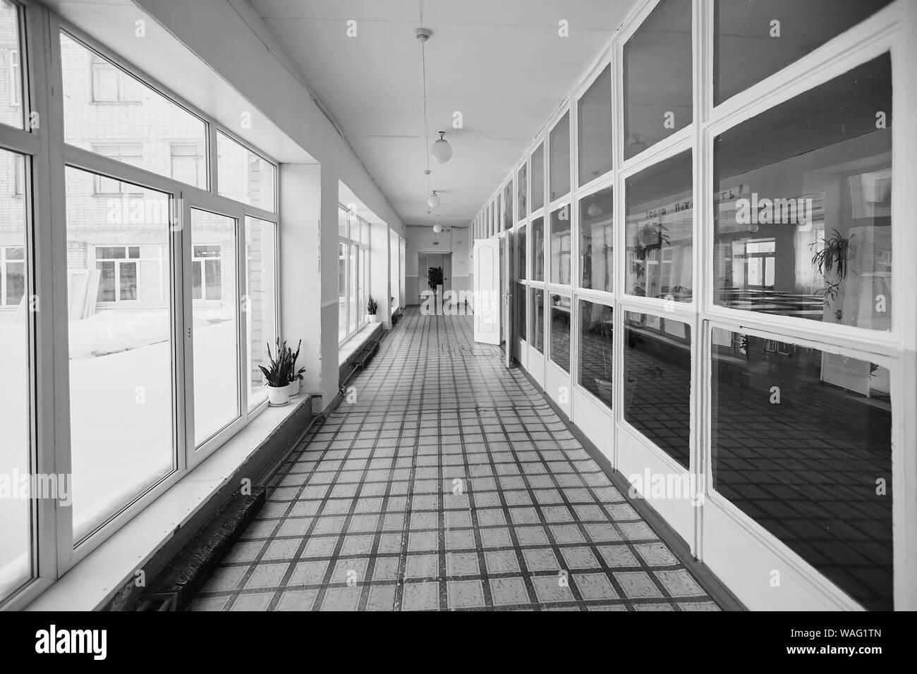 Blick in den Eingangsflur, alte Schule oder Mehrfamilienhaus, dead End lange und schmale Gehweg und Glasfenster mit frühen Morgen orange Shin Stockfoto