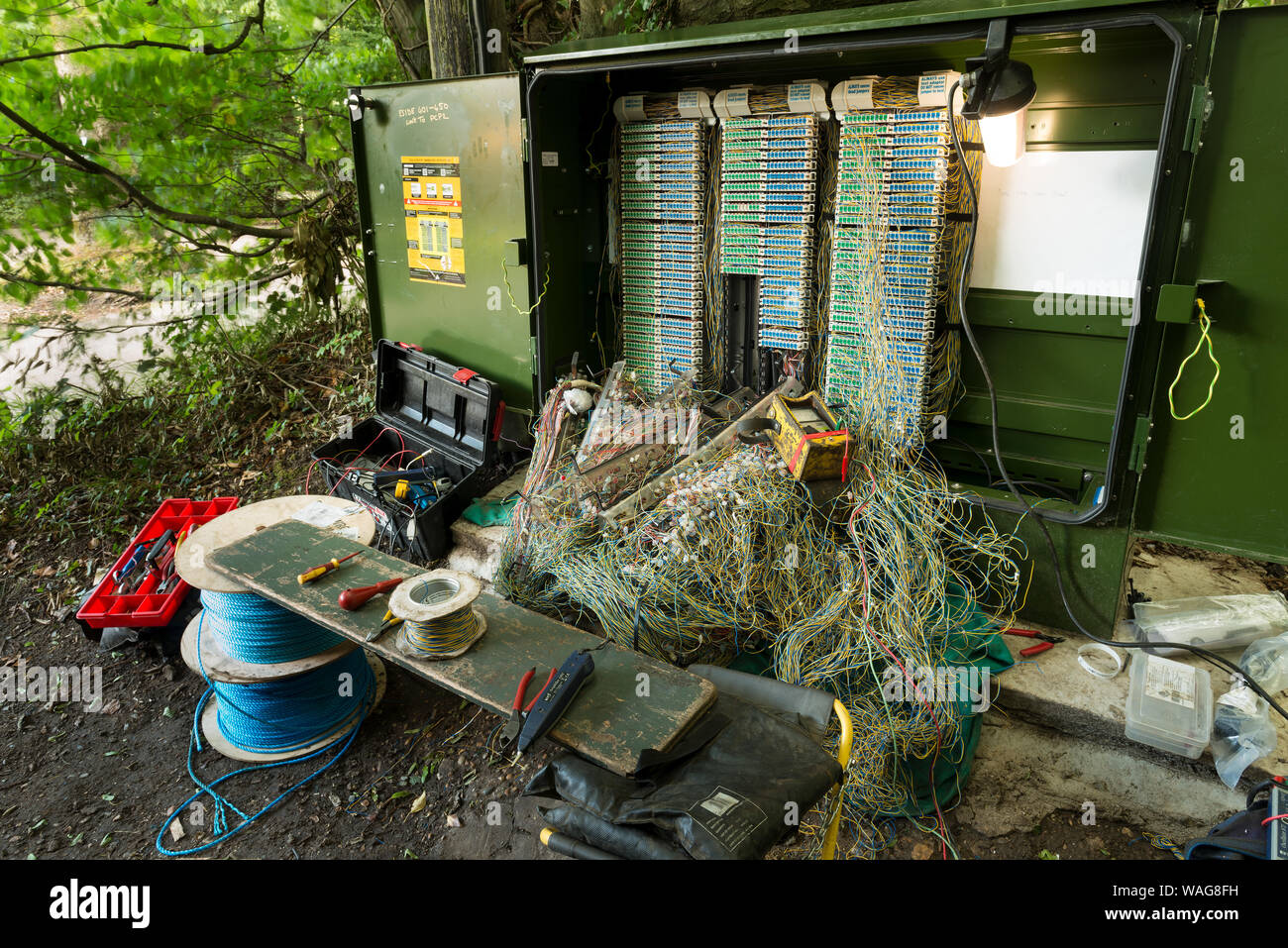 Verworrene Masse von verdrillten Telefonleitungen in einem Netzwerk auf öffentlichen Fußweg repariert wird, präsentiert ein echtes Rätsel, Links auf Kaffee Pause Stockfoto