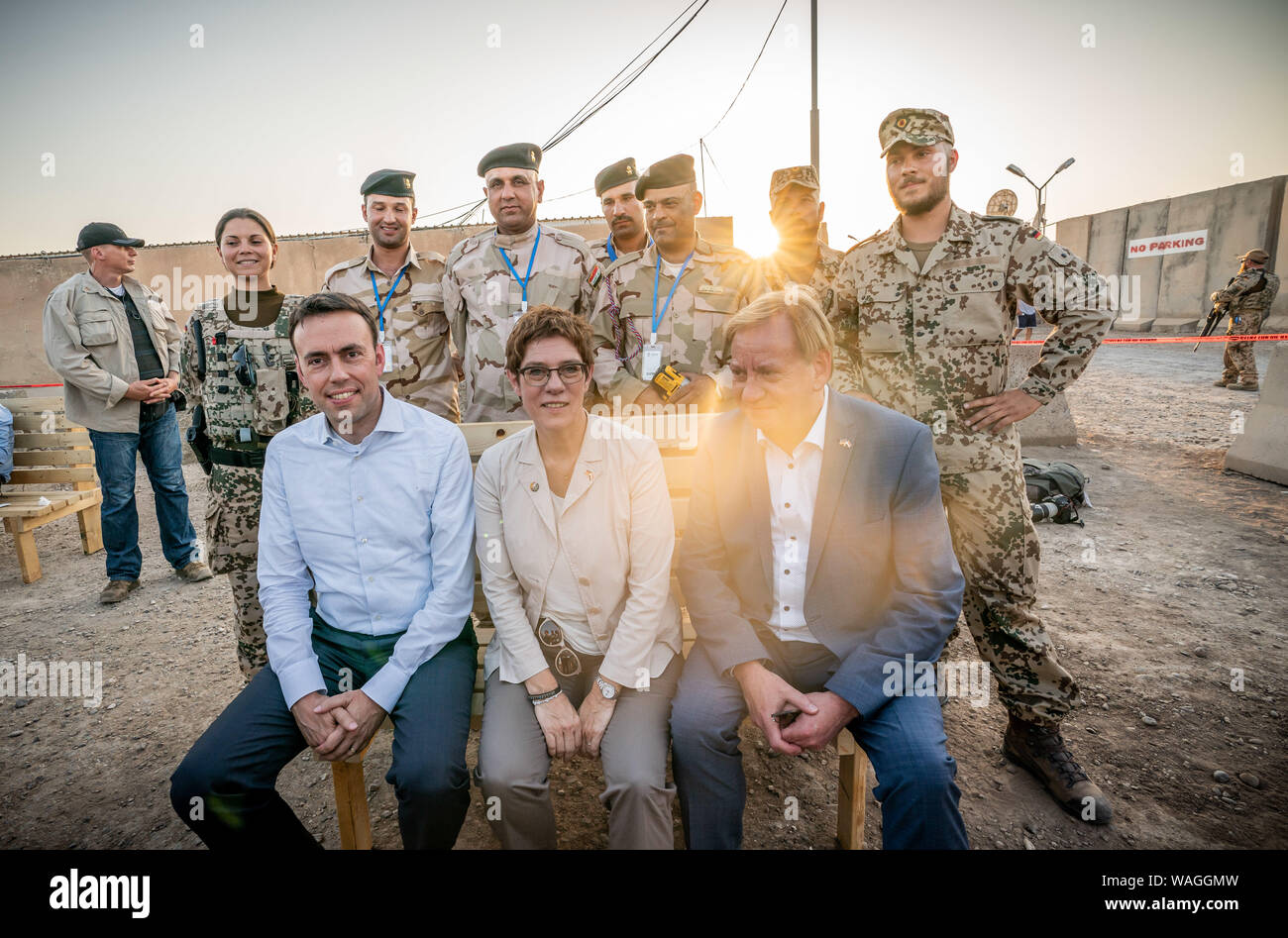 Bagdad, Irak. 20 Aug, 2019. Annegret Kramp-Karrenbauer (CDU), Minister für Verteidigung, sitzt auf einer Bank zwischen Ingo Gädechens (CDU, vorne rechts) und Nils Schmid (SPD, vorne links), Mitglieder des Bundestages, der zuvor gezimmert Pioniere hatten mit irakischen Soldaten, wenn die Soldaten der Bundeswehr besuchte die internationale militärische camp Camp Taji. Der Minister und CDU-Chefin ist die Durchführung von politischen Gesprächen in der Hauptstadt Bagdad und ist es, die deutschen Soldaten, die in die Ausbildung lokaler Kräfte im Land beteiligt sind. Quelle: Michael Kappeler/dpa/Alamy leben Nachrichten Stockfoto
