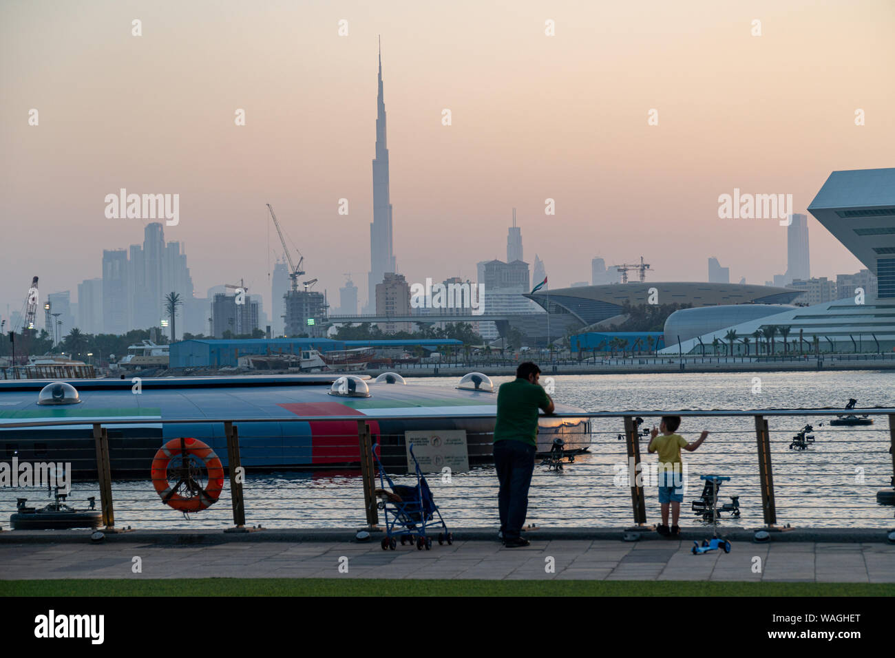 Vater und Sonne Sonnenuntergang über Dubai Down Town mit Burj Khalifa im Zentrum. Blick von der Dubai Festival City. Stockfoto