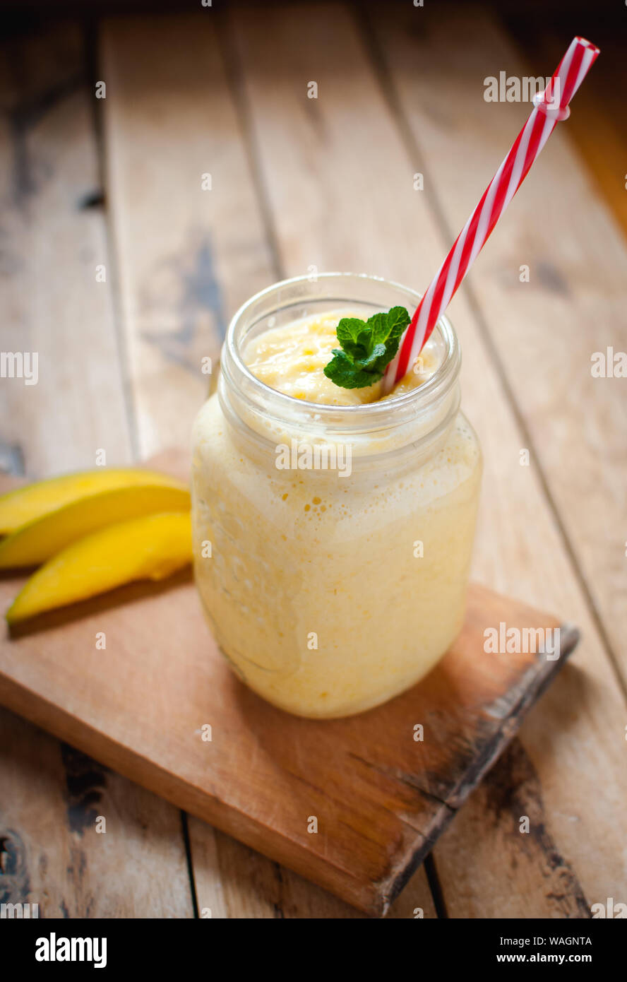 Mango Smoothie in einem Glas auf hölzernen Tisch Stockfoto