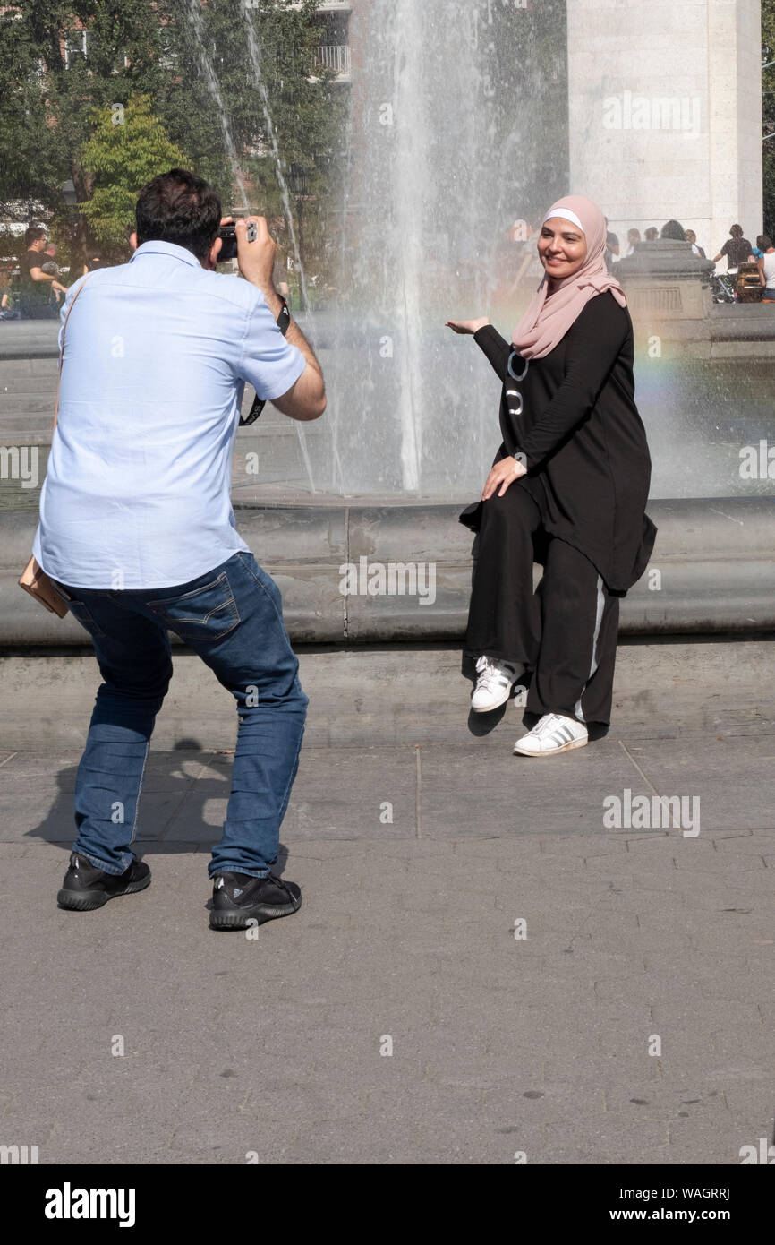 Eine islamische Frau in einer Hijab und in bescheidenen Kleid posiert für ein Foto bei der Brunnen im Washington Square Park in Greenwich Village, Manhattan, New York. Stockfoto