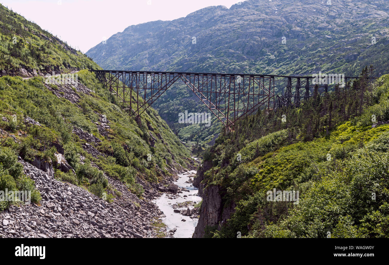 Historische Stahlbrücke über den White Pass Schlucht 18 Meilen nördlich von skagway Alaska von bewaldeten, felsigen Bergen umgeben Stockfoto