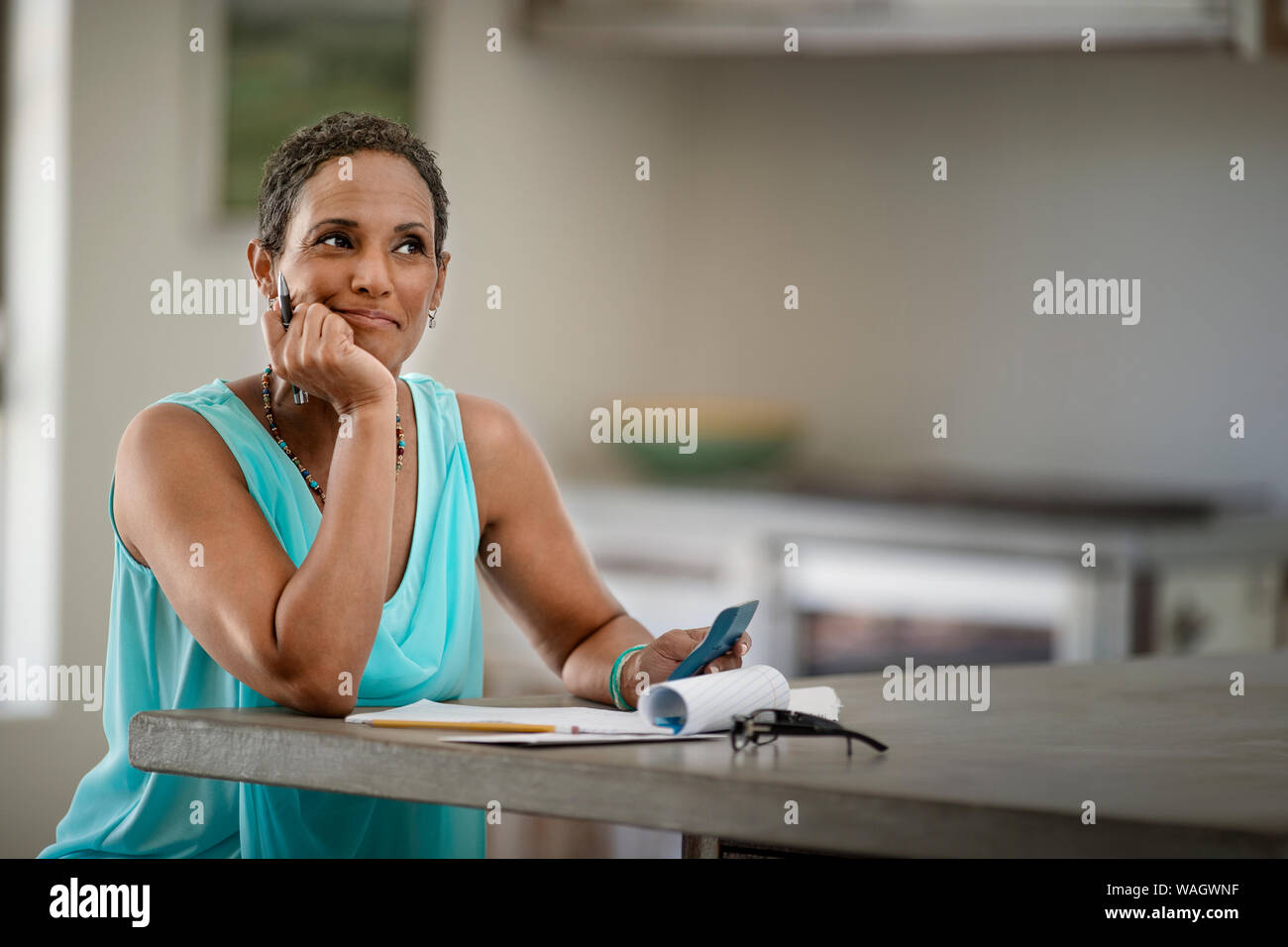 Frau liest an der Arbeitsplatte in der Küche Stockfoto