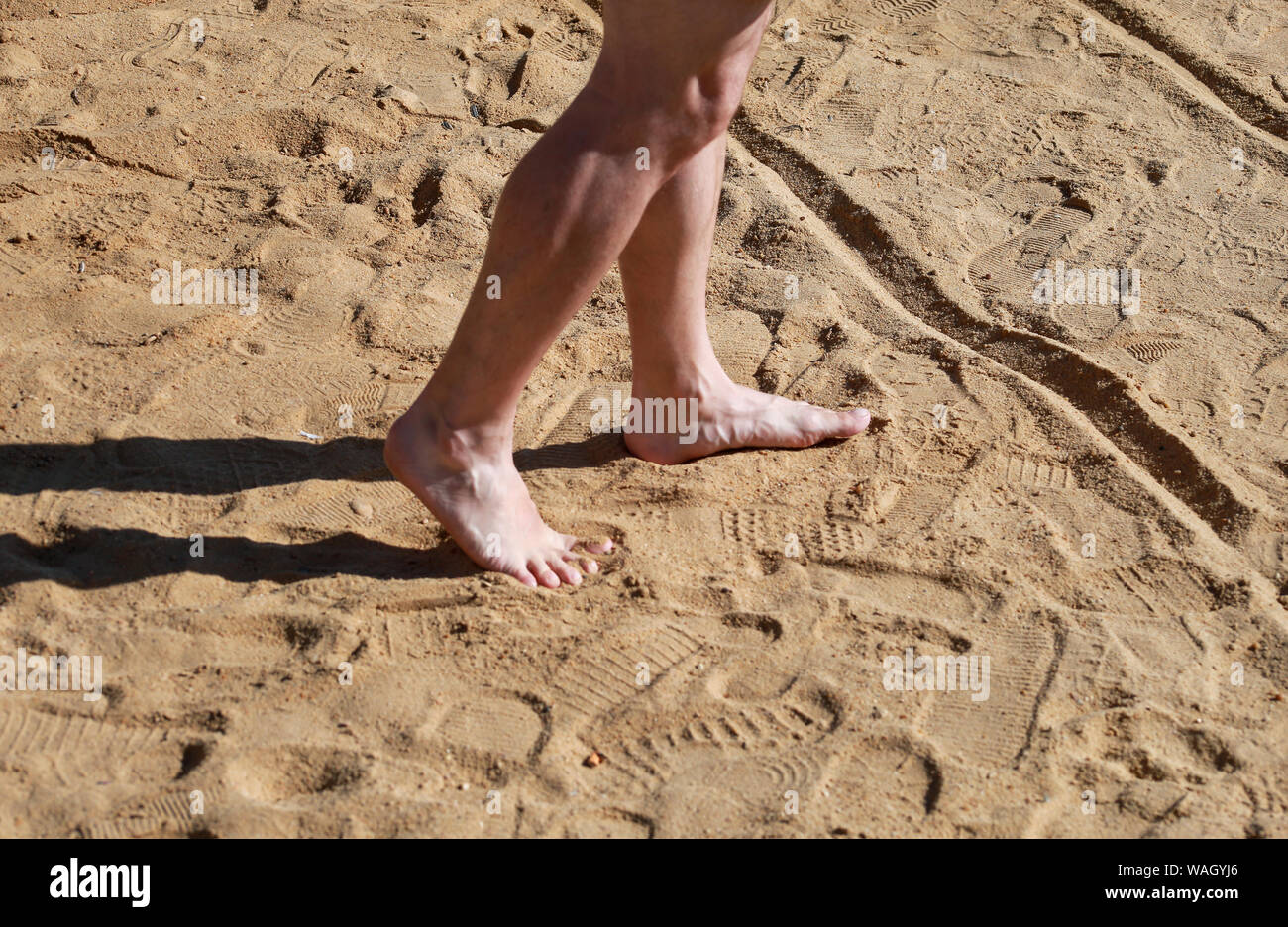 Mann Beine auf Sand. Männliche Füße zu Fuß auf schönen Sandstrand von Hotel Resort am Roten Meer in Ägypten, tun und hinter Fußspuren im Sand hinterlassen. Stockfoto