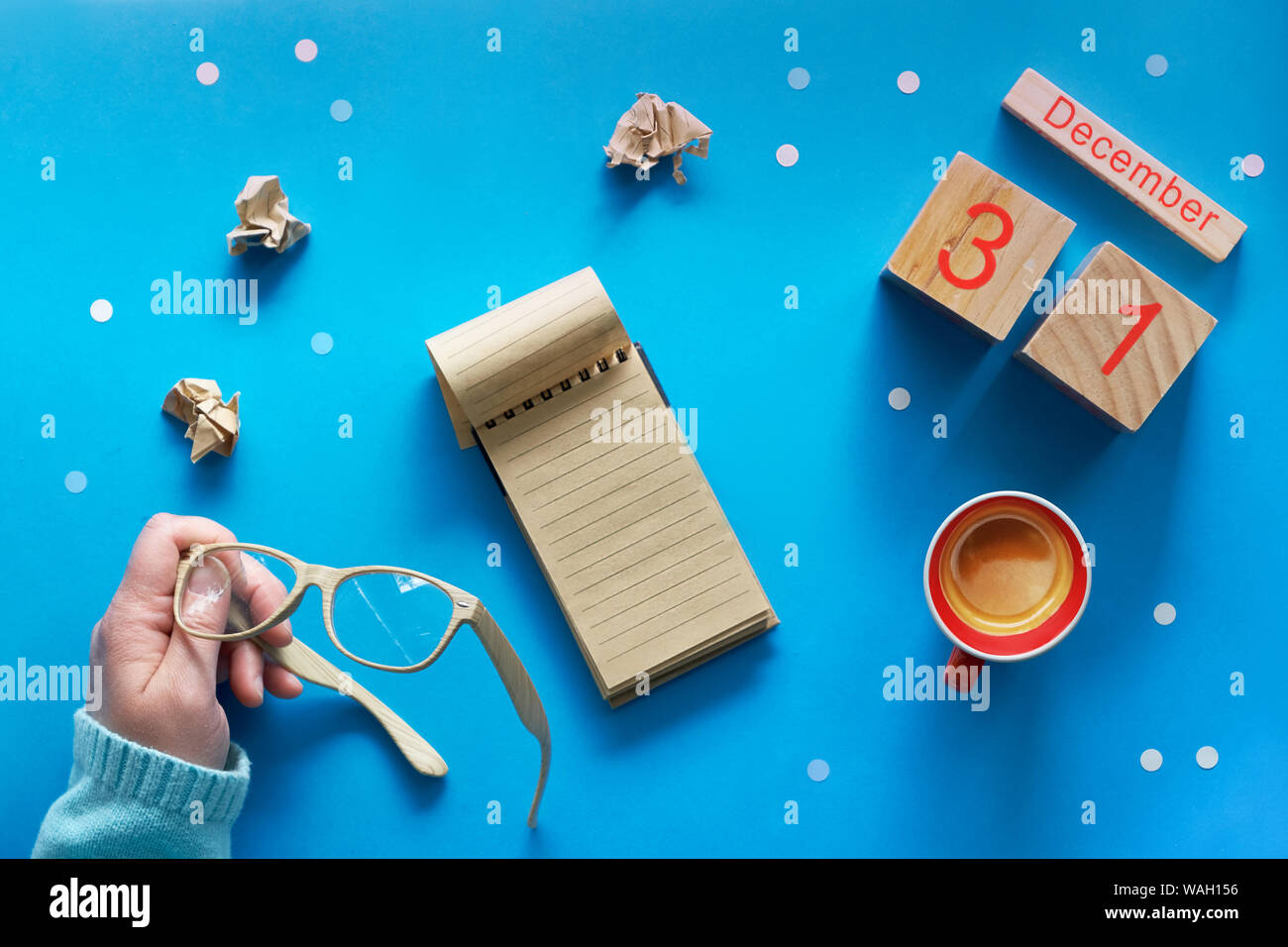 Weihnachten Hände Liste und der Frau mit Stift, Notizbuch, Kalender und Kaffee auf Blau pastell Tabelle Ansicht von oben. Flach Stil, blaues Papier Hintergrund mit Stockfoto