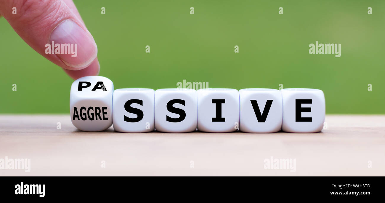 Hand einen Würfel und Änderungen das Wort 'passiven' zu "aggressiv", oder umgekehrt. Stockfoto