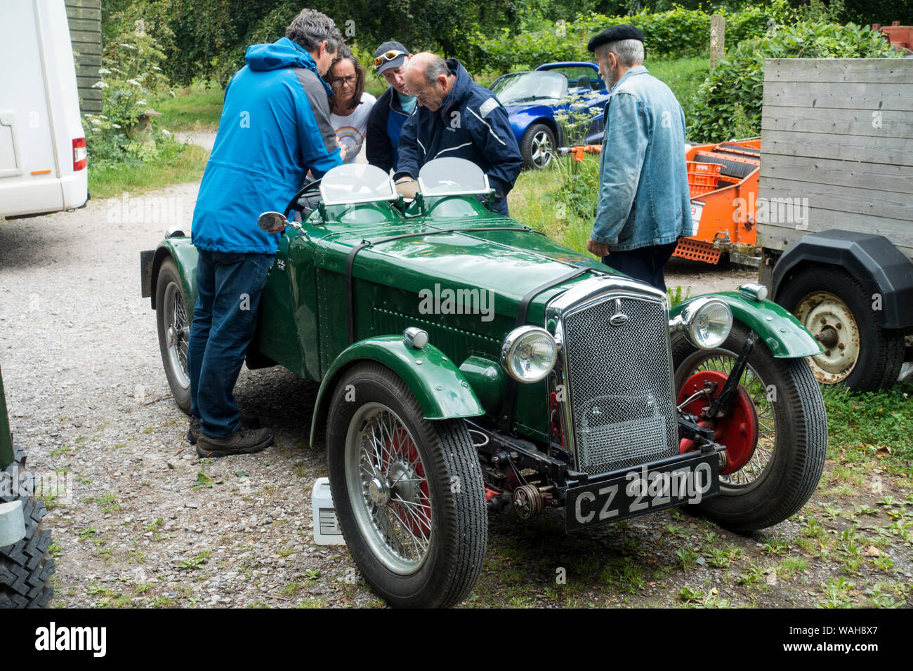 Menschen im Gespräch, über einen Vintage Wolseley Sportwagen, England, UK. Stockfoto