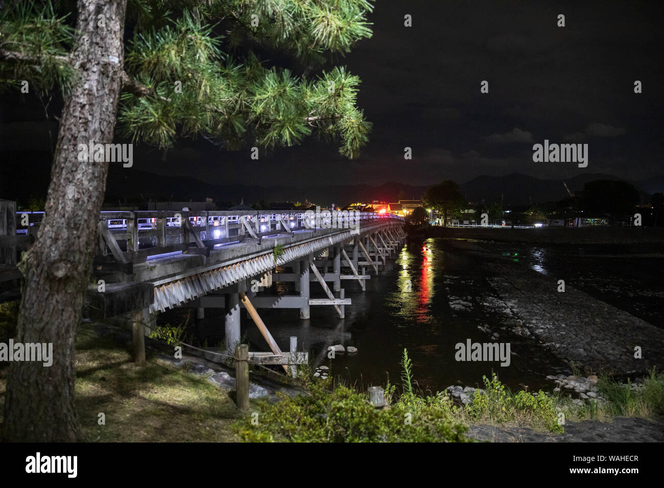 Alte Holzbrücke überquert den Fluss nach Arashiyama bei Nacht Stockfoto