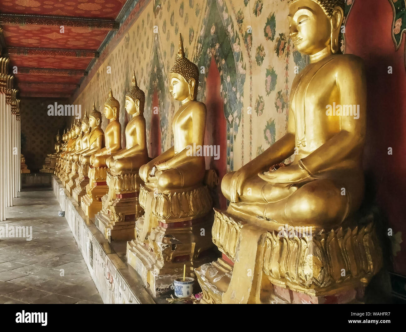 Kreuzgang mit vielen Buddha Statuen am Wat Arun Tempel in Bangkok. Stockfoto