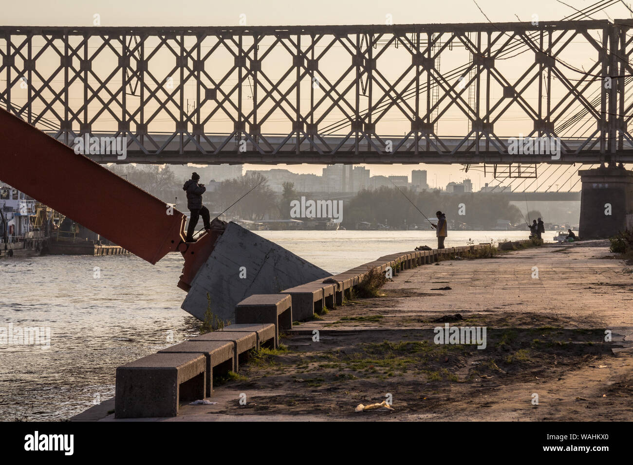 Belgrad, SERBIEN - November 23, 2014: Fischer mit ihren Stangen unter Brücken am Ufer der Ufer des Flusses Sava in der Dämmerung Bild Stockfoto