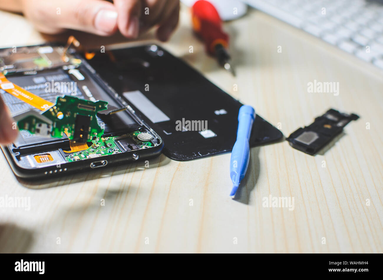 Der Mensch ist die Reparatur von einem Mobiltelefon. Stockfoto
